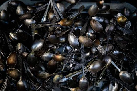 Background texture of tea silver teaspoons and cutlery. Shiny golden tea spoo Stock Photos