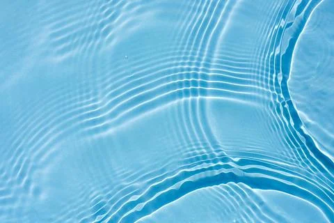 Background, texture of transparent blue water with ripples and waves Stock Photos