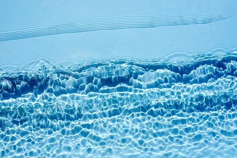 Background, texture of transparent blue water with seething ripples , waves Stock Photos
