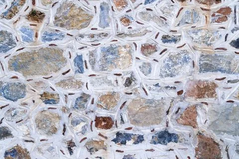 Background texture of wall made of colored stones. Stock-Fotos