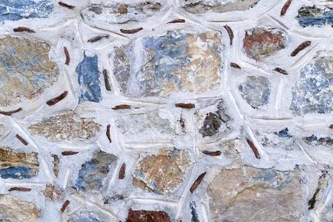 Background texture of wall made of colored stones. Stock Photos