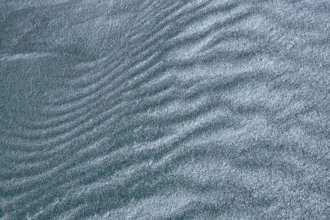 Background, texture, wave pattern of oceanic sand on the beach, blue-gray Foto stock