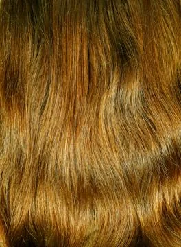 Background texture of wavy light brown human hair strands Stock Photos