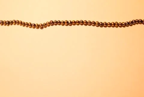 Background from textured paper and a string of black pearls Stock Photos