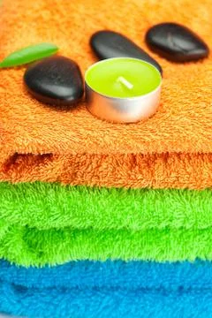 Background of the three multi-colored bath towels, black spa stones, green le Foto stock