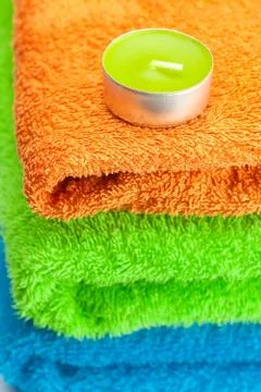 Background of the three multi colored terry towels and candle Stock Photos