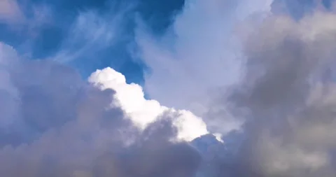 A background of thunderstorm clouds covering a blue piece of sky with a whit 스톡 동영상 338307047