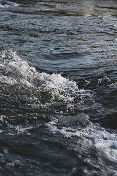 Background, top view, rapid flow river with dark blue water and white foam wa Stock Photos