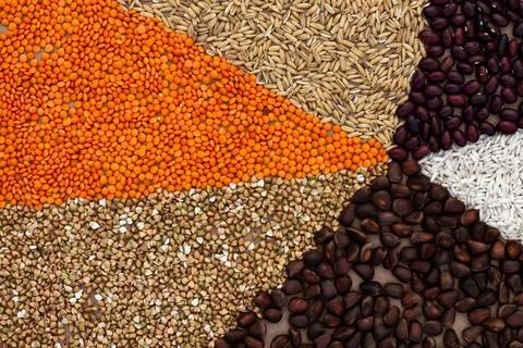 Background of triangles lined with various cereals and nuts on a craft paper. Stock Photos