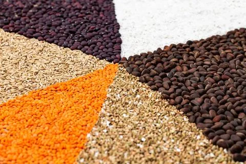 Background of triangles lined with various cereals and nuts on a craft paper. Stock Photos