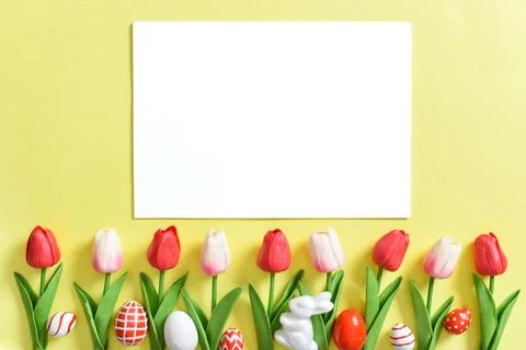 Background with tulips and Easter eggs on a yellow background with a white .. Stock Photos