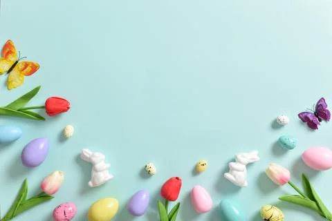 Background with tulips, Easter eggs and butterflies on a blue background. Stock Photos