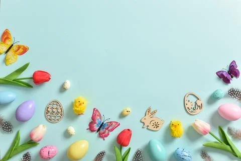 Background with tulips, Easter eggs and butterflies on a blue background. Foto stock