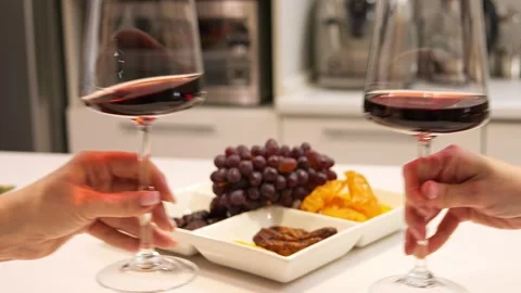 In background two glasses of wine collide reflecting the essence of camaraderie Stock Footage 272921929