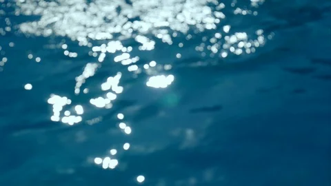Background of the undulating surface of the pool water. The rays of the sun Stock Footage