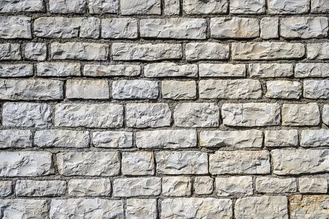 Background from a uniform natural stone wall Stock Photos
