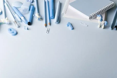 Background with various light blue stationery lying at the top on a light blu Stock Photos
