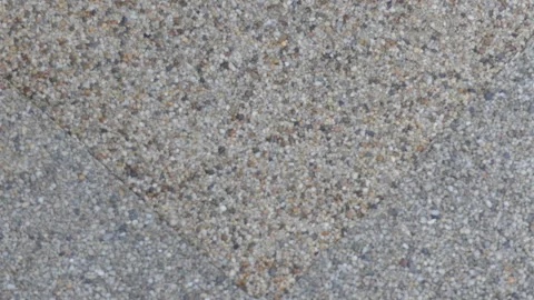 A background video of a sandy textured paving slab. Stock Footage 289881624