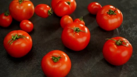 Background video showing cherry tomatoes falling on the table in slow motion. Stock Footage 269930977