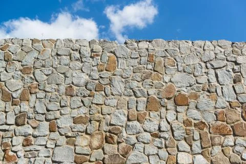 Background from the wall built from large natural stone limestone. The top li Stock Photos