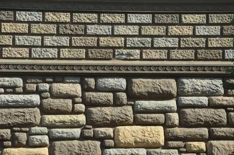 The background of the wall is decorative light beige stone and brick. Facade Foto stock