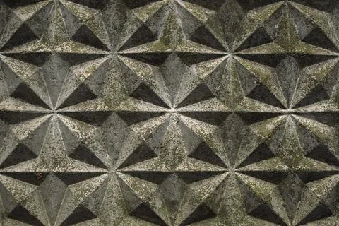 Background, wall of gray blocks with triangular patterns and shadows of the s 스톡 사진