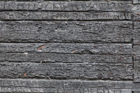 Background wall of horizontal charred black boards in the form of coals. Fire Stock Photos