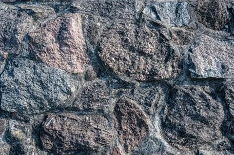 Background of the wall of large granite textured stones Stock Photos