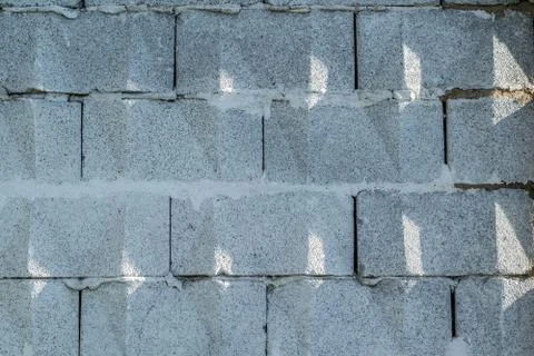 Background, wall of large gray brick blocks with triangular patterns Stock Photos