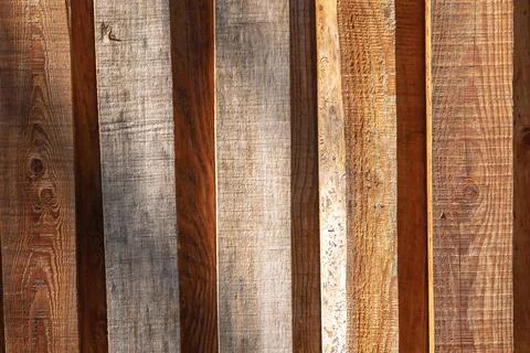 A background wall, made of vertical, brown wooden planks. Stock Photos