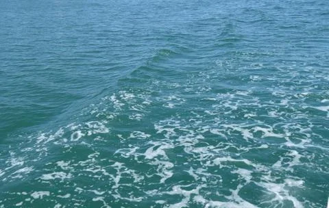 Background with wave and foam, trace on the surface of the water behind the f Foto stock