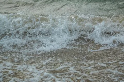 Background of waves beating on a sandy beach in stormy weather Stock Photos