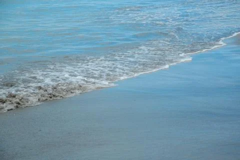 Background of waves beating on a sandy beach in stormy weather Stock Photos