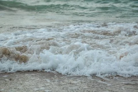 Background of waves beating on a sandy beach in stormy weather Stock Photos