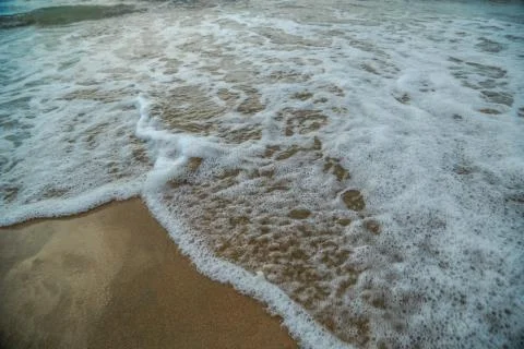 Background of waves beating on a sandy beach in stormy weather Stock Photos