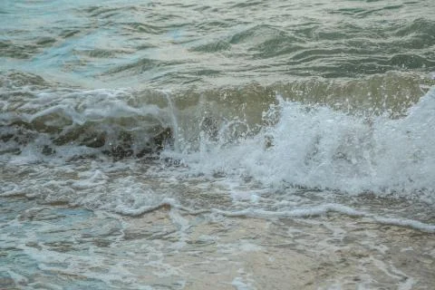 Background of waves beating on a sandy beach in stormy weather Stock Photos