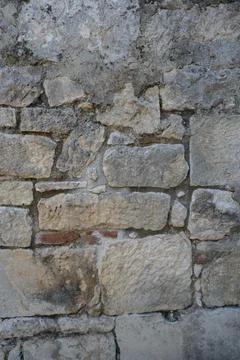 Background of weathered stone wall with ancient stonework. Stock Photos