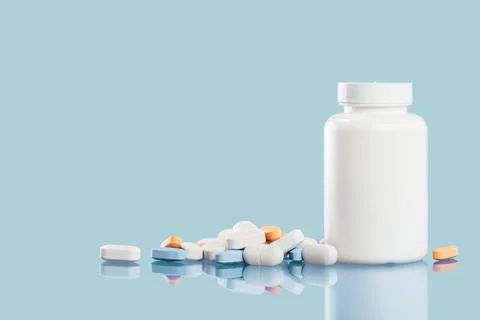 Background of white tablets or pills on blue table. Medicine and pharmacy Stock Photos