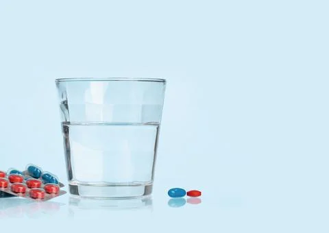 Background of white tablets or pills on blue table. Medicine and pharmacy Stock Photos