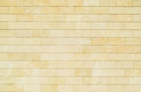 Background of yellow bricks. Wall of yellow bricks. The texture of the wall. Stock Photos