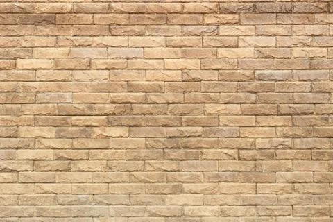 Background of yellow facing bricks. Bricks relief close up. Stock Photos
