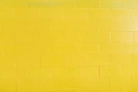Background of yellow painted bricks wall, Tuscany in Italy Stock Photos