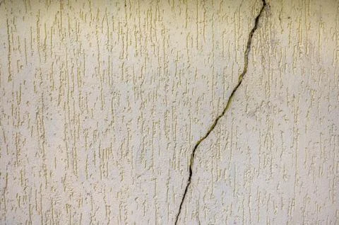 Background is a yellow texture stone wall with a crack in the middle Stock Photos