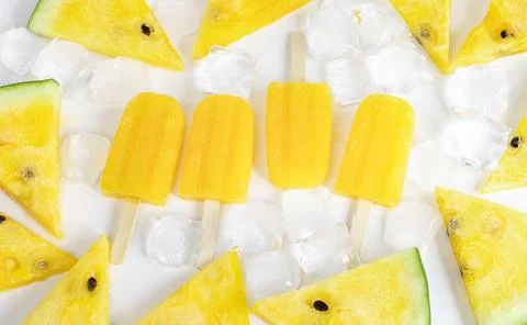 Background with yellow watermelon popsicles. Stock Photos
