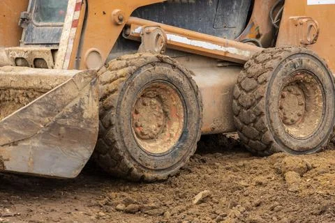 A backhoe is actively digging and moving dirt at a construction site, demon.. Stockfoto's