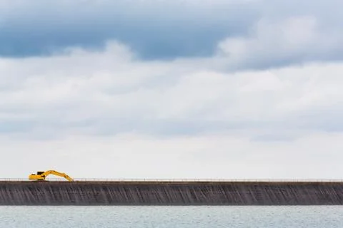 Backhoe on dam crest Stock Photos