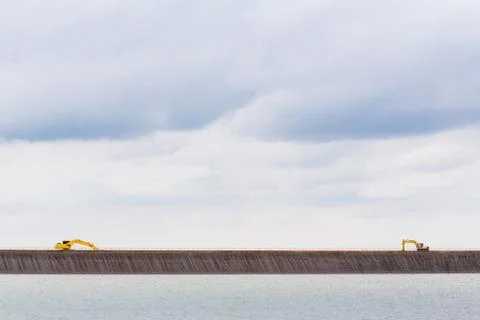 Backhoe on dam crest Stock Photos