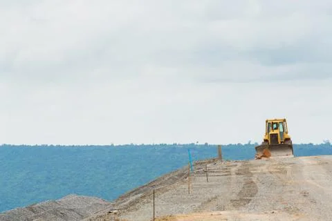 Backhoe on dam crest Stock Photos