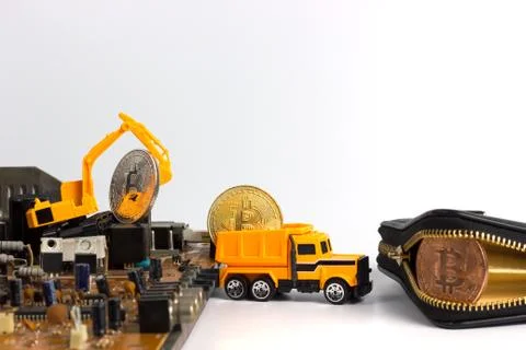 Backhoe dig bitcoin on mainboard. Stock Photos