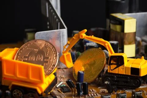 Backhoe dig bitcoin on mainboard. Stock Photos